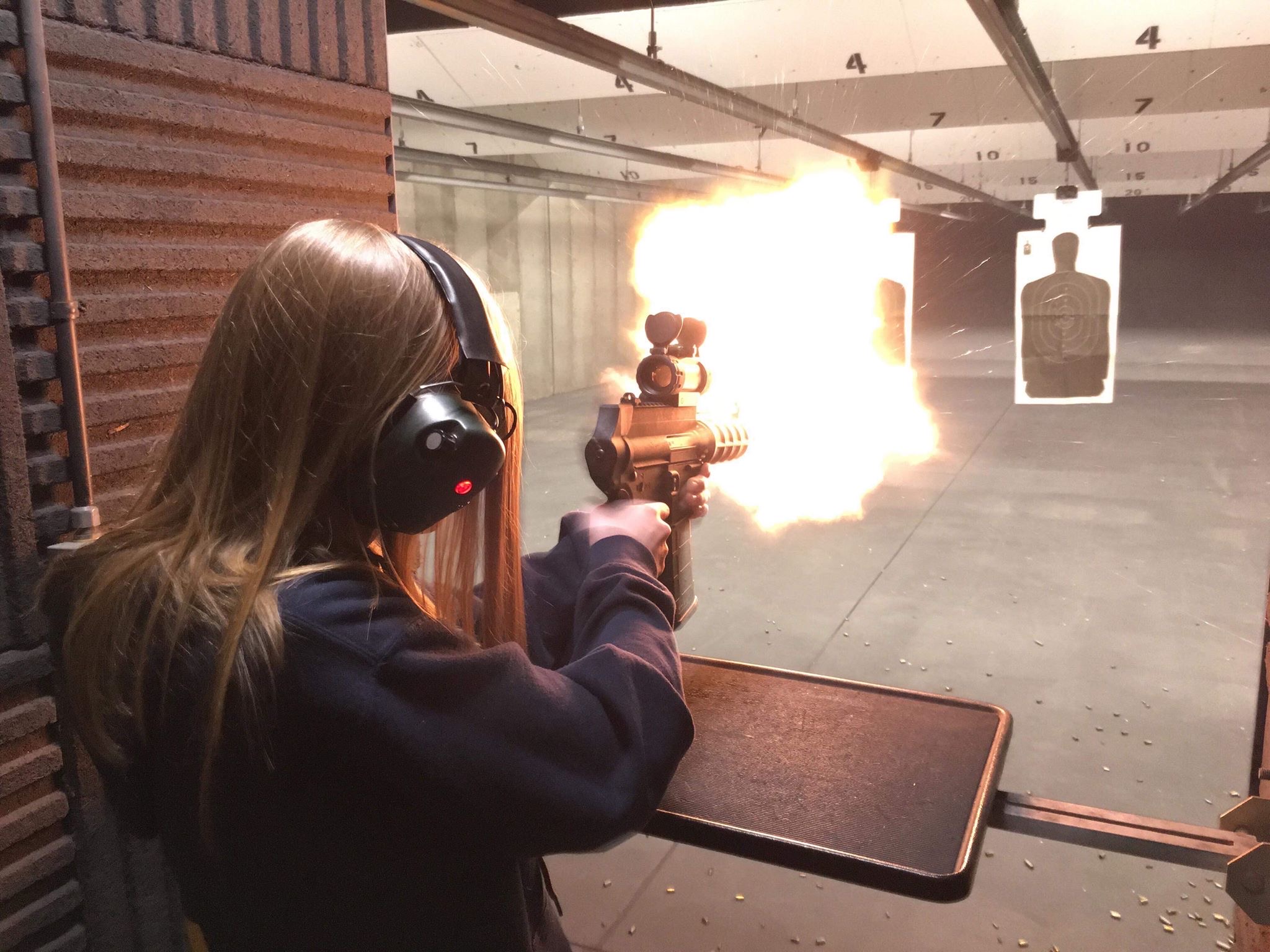 girl shooting rifle in an indoor shooting range