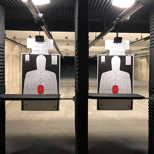 Indoor shooting range lanes with paper targets no firearm webinars in it