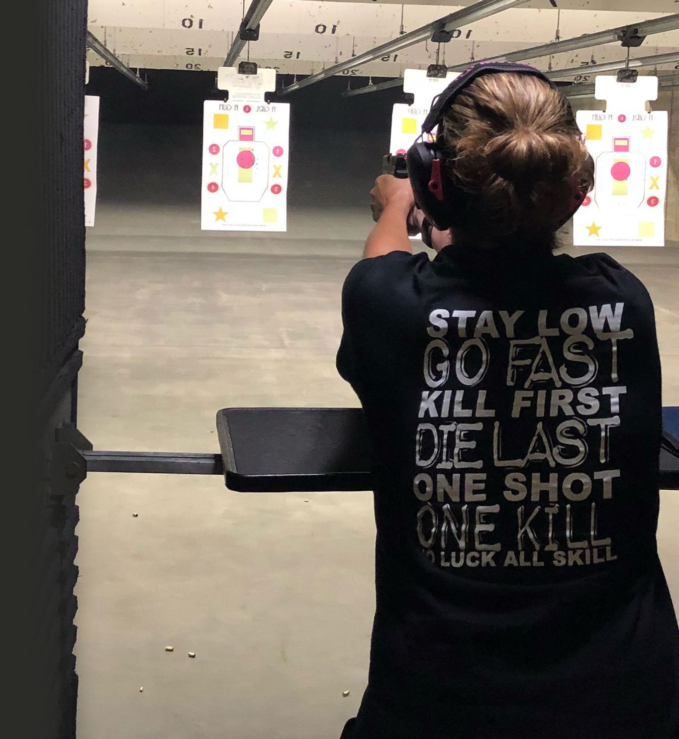lady shooting firearm inside an indoor gun range