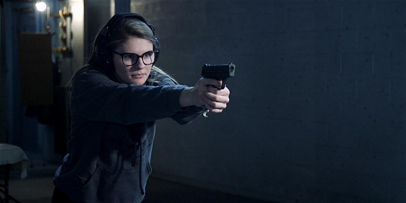 Lady shooting pistol in an indoor shooting range